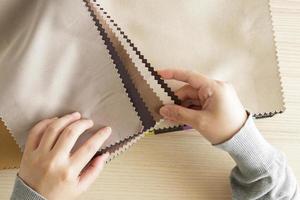 diseñadora femenina con muestras de color de tela eligiendo textiles para cortinas foto