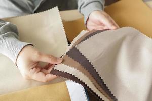 female designer with fabric color samples choosing textile for curtains photo