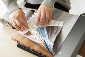 diseñadora femenina con muestras de color de tela eligiendo textiles para cortinas foto