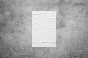 Blank white wheatpaste glued paper poster mockup on concrete wall background photo