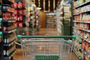 empty green shopping cart in supermarket aisle interior background photo