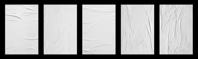 white crumpled and creased glued paper poster set isolated on black background photo