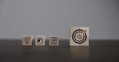 Target or goal with strategy plan, success business revenue concept. Symbols of arrows, diagrams businesses are present on wood cube. objective management, achievement startup, growth marketing idea. photo