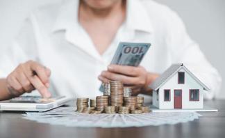 Saving investment home with loan finance money business concept. Investment banking finance for residential real estate business. Stack coins with model house for investment loans.Cash for taxes. photo