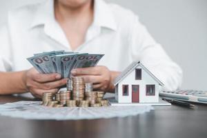 Saving investment home with loan finance money business concept. Investment banking finance for residential real estate business. Stack coins with model house for investment loans.Cash for taxes. photo