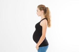 Retrato de perfil de mujer caucásica rubia con vientre embarazado aislado sobre fondo blanco. concepto de embarazo. copie el espacio foto