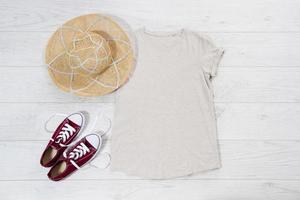 White t shirt mock up flat lay on wooden background. Top view and copy space. Mockup t-shirt and summertime. Template blank shirt. photo