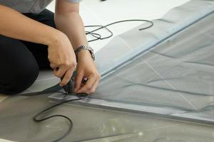 man install mosquito net wire screen on house window protection against insect photo