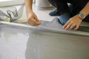 man install mosquito net wire screen on house window protection against insect photo