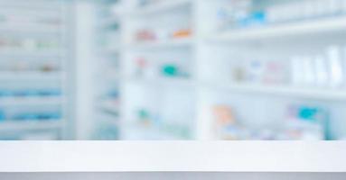 Empty white counter with pharmacy drugstore shelves blurred background photo