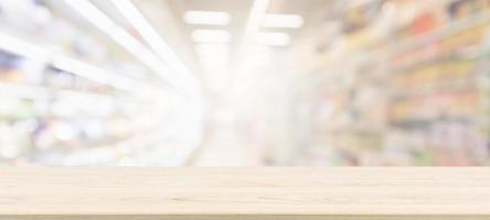 Wood table top with supermarket grocery store blurred background with bokeh light for product display photo