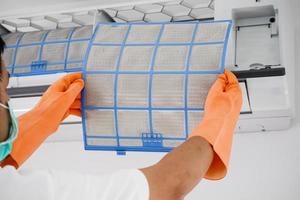 Asian man cleaning air conditioner dirty filter photo