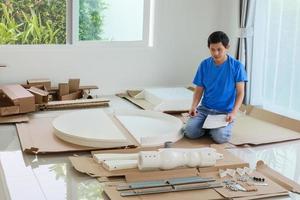 hombre montando muebles de mesa redonda blanca en casa foto