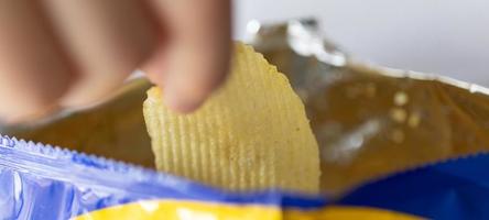 Hand hold potato chips with snack bag photo