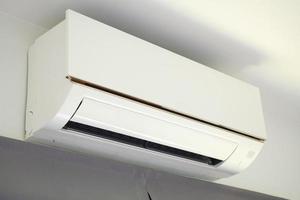 Air conditioner on white wall room interior background photo