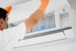 Asian man cleaning air conditioner dirty filter photo