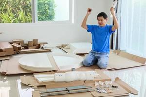 Man assembling white round table furniture at home photo