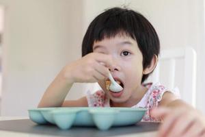 Little asian girl having breakfast photo