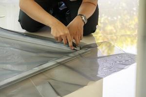 man install mosquito net wire screen on house window protection against insect photo
