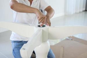 Asian man assembling white table furniture at home photo