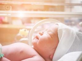 Newborn baby inside incubator in hospital post delivery room photo