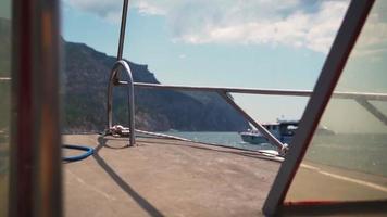 View from a sailing yacht along the turquoise sea along the coast. Summer vacation and travel concept. Slow motion. video