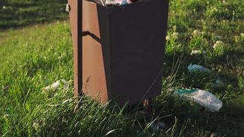Überlaufender Mülleimer im Freien bei Sonnenuntergang. Konzept der Umweltverschmutzung. Plastik-Müll. video