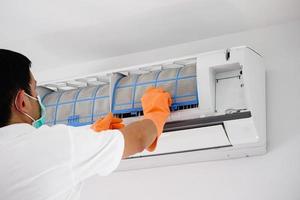 Asian man cleaning air conditioner dirty filter photo