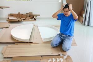 hombre montando muebles de mesa redonda blanca en casa foto