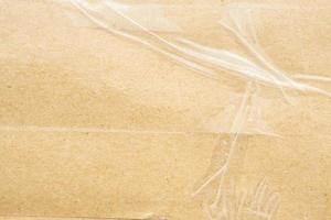 transparent adhesive tape on old brown cardboard paper background photo