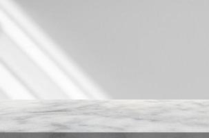 Marble table with window shadow drop on white wall background for mockup product display photo