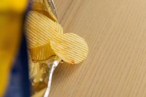 patatas fritas crujientes en una bolsa de bocadillos en una mesa de madera foto