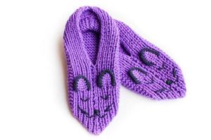 Handmade knitted pink slippers with muzzles. On white background you can easily place text or change the background photo