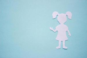 The silhouette of a girl in a dress and with ponytails made of white paper, cut by hand. With speech-bubble in the right side of the photo. With copy space photo