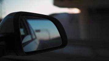 Visualizza a partire dal di il lato specchio il dentro di un' guida auto lungo il autostrada nel un' soleggiato giorno. concetto di veicoli e trasporto. no le persone. video