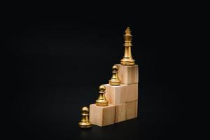 wooden cube and chess, business and marketing strategy concept in planning goals on black background. photo