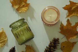 Autumn composition with aromatic candle, dry citrus, cinnamon. Aromatherapy on a grey fall morning, atmosphere of cosiness and relax. Wooden background close up photo