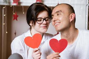 pareja enamorada sosteniendo un corazón rojo en sus manos foto