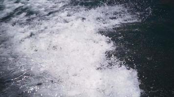 de cerca. un bote a motor atraviesa el agua clara del mar en movimiento. camara lenta. video