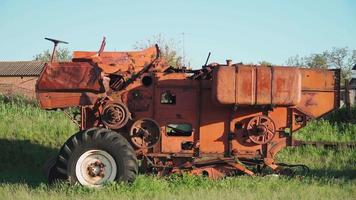 Old rusted tractor aged on farm land. Abandoned agricultural machinery video