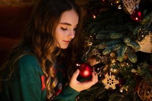 Cute little girl in green knitted northern reindeer sweater, caucasian girl photo