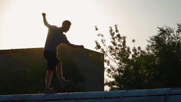 Playful happy man runs and rejoices at success. A young guy funny running and jumps with happiness against the backdrop of a beautiful sunset. Slow motion video