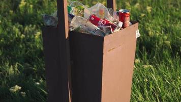 Overflowing trash bin outdoors in sunset light. Environmental pollution concept. Plastic waste. video