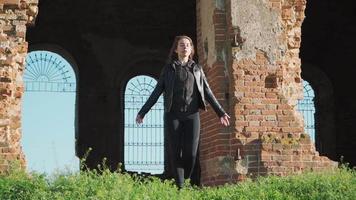 A young woman stands against the background of a beautiful old building raises his hands up. The joy of victory. Motivational video. Slow motion. Shooting on the Steadicam video