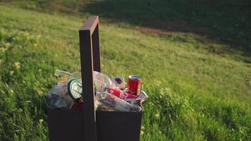poubelle débordante à l'extérieur à la lumière du coucher du soleil. notion de pollution de l'environnement. Déchets plastiques. video