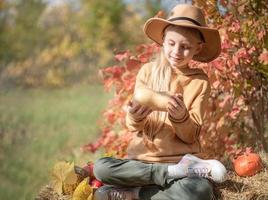 Girl in the hay with pumpkins photo