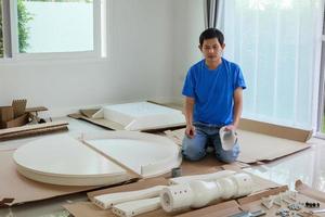 hombre montando muebles de mesa redonda blanca en casa foto