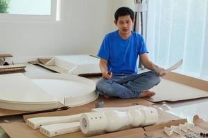 hombre montando muebles de mesa redonda blanca en casa foto