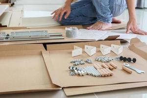 Man assembling white round table furniture at home photo