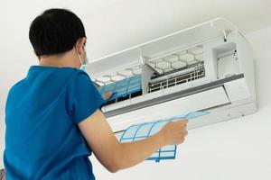 Asian man cleaning air conditioner filter photo